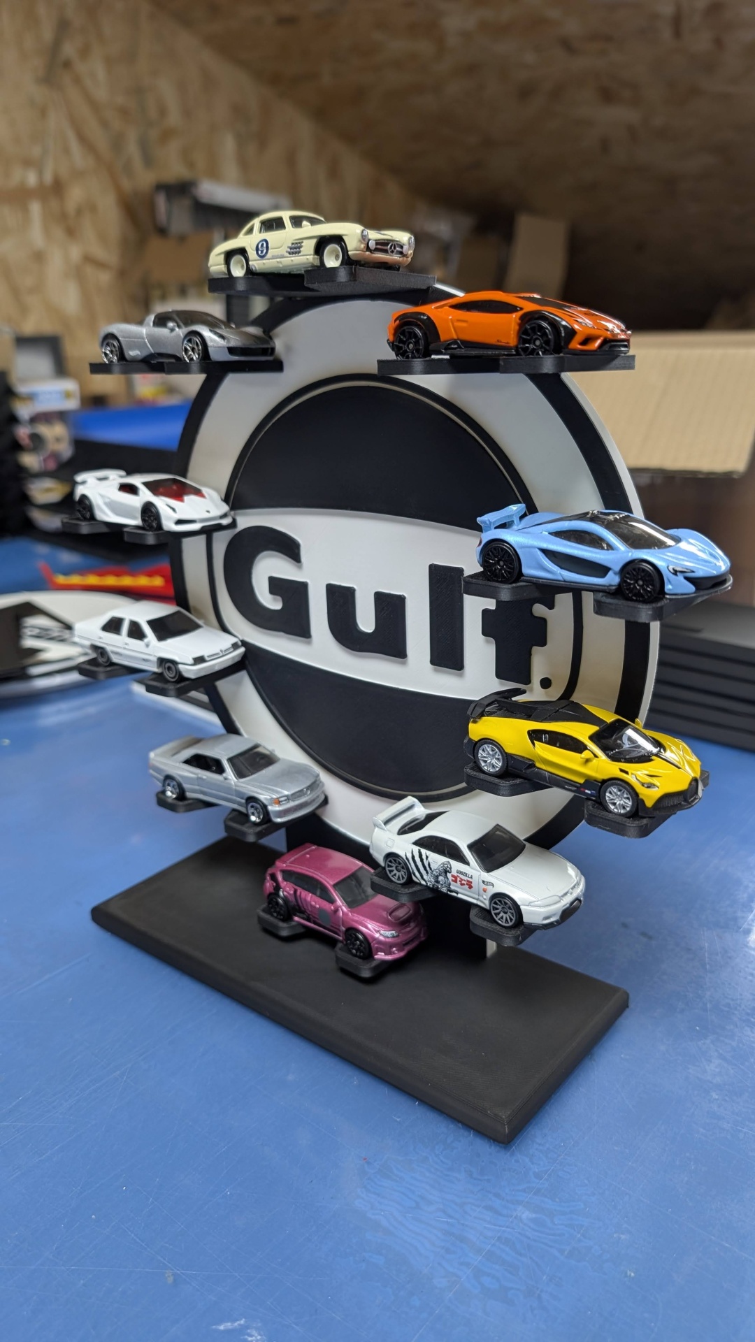 Carrinhos de coleção em miniatura expostos em suporte com logo Gulf