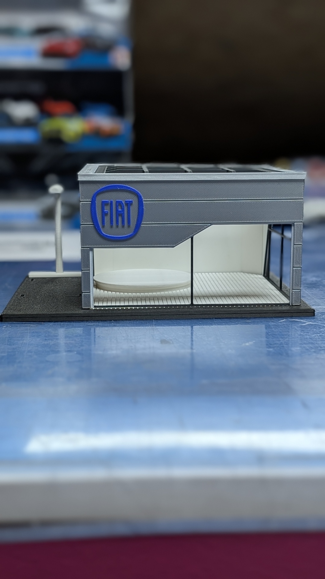 Maquete de montra de loja FIAT cinzenta com vidro e sinal azul