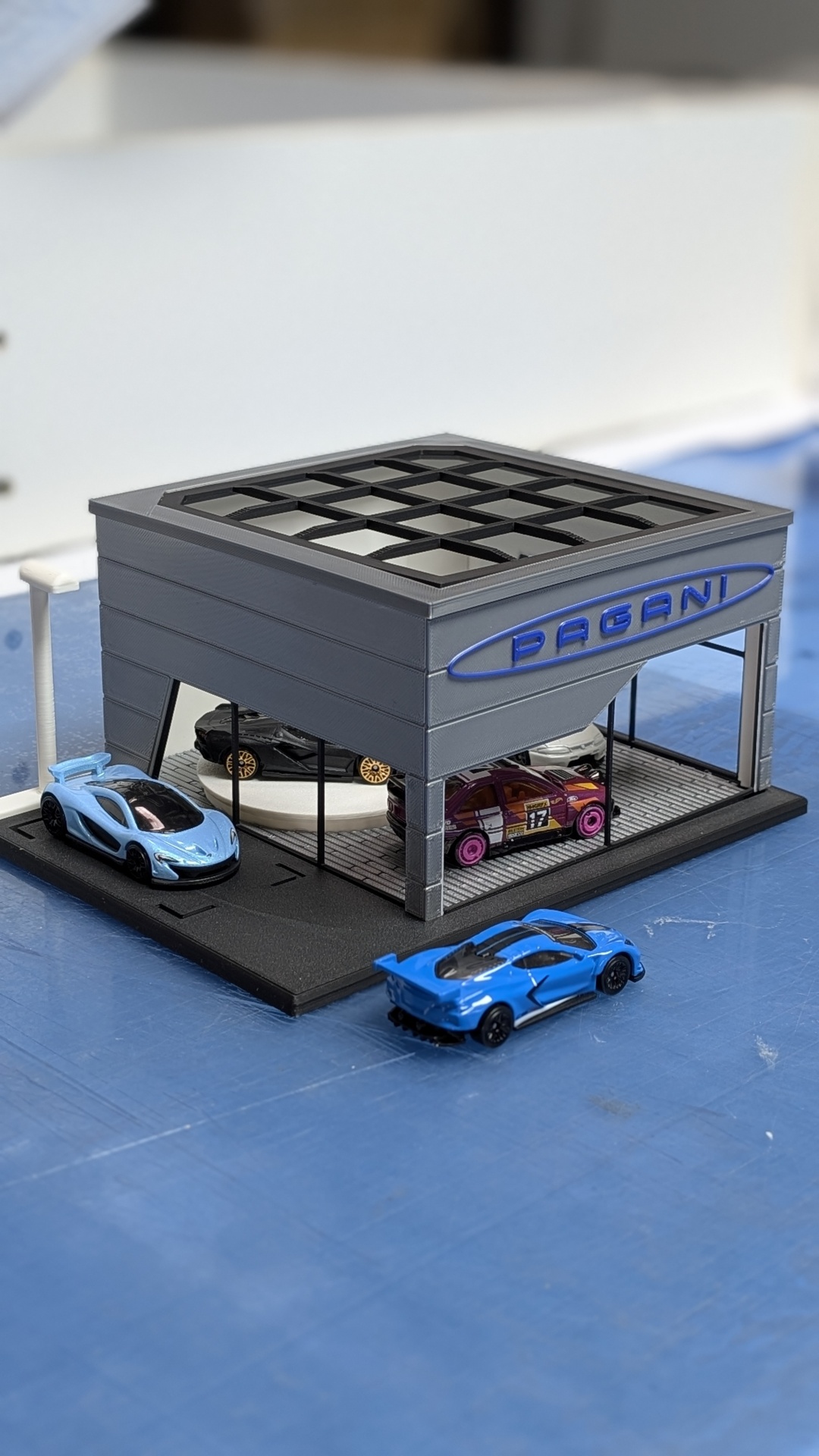 Miniatura de concessionária PÅGANI com carros de brinquedo coloridos