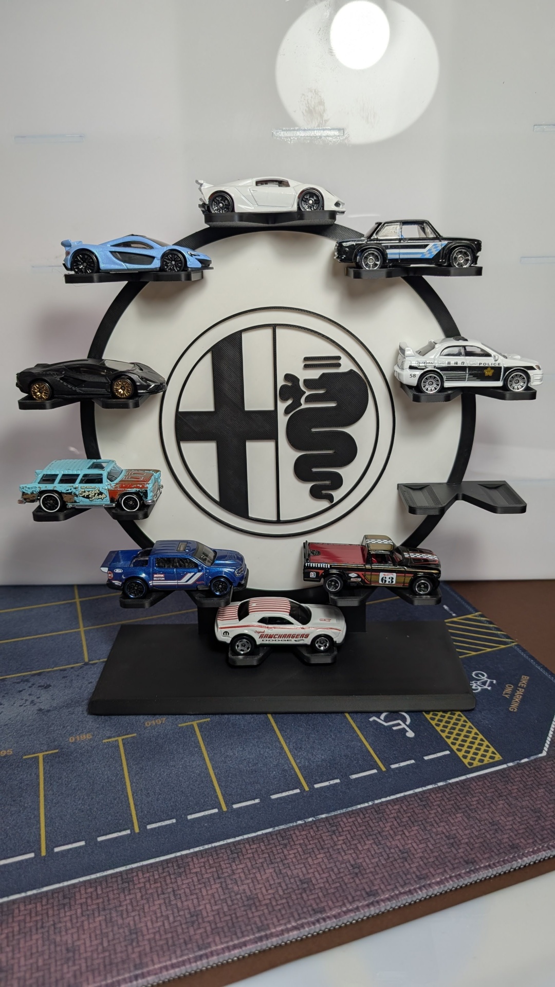 Expositor de miniaturas de carros coloridos com logótipo e base preta.