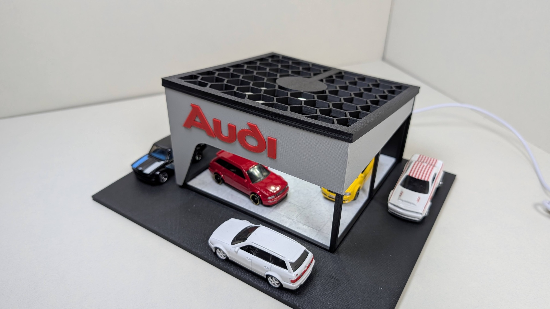 Miniatura de garagem Audi com carros em plástico coloridos