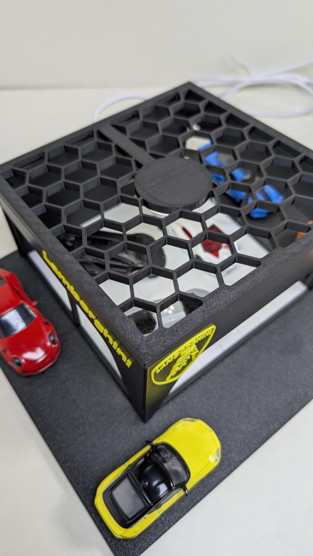 Mini carrinhos vermelho e amarelo com caixa preta padrão hexagonal e logótipos Lamborghini