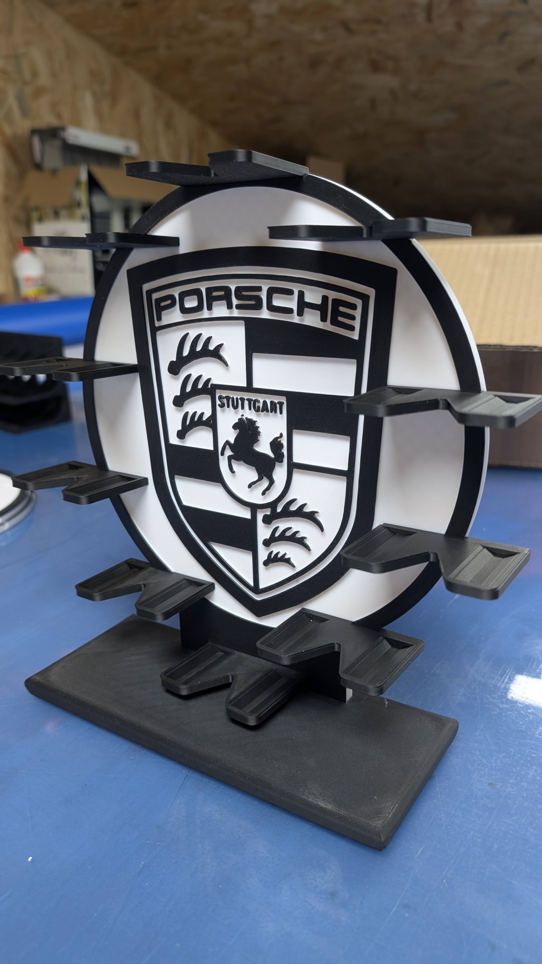 Suporte preto e branco com logótipo Porsche e várias prateleiras pequenas