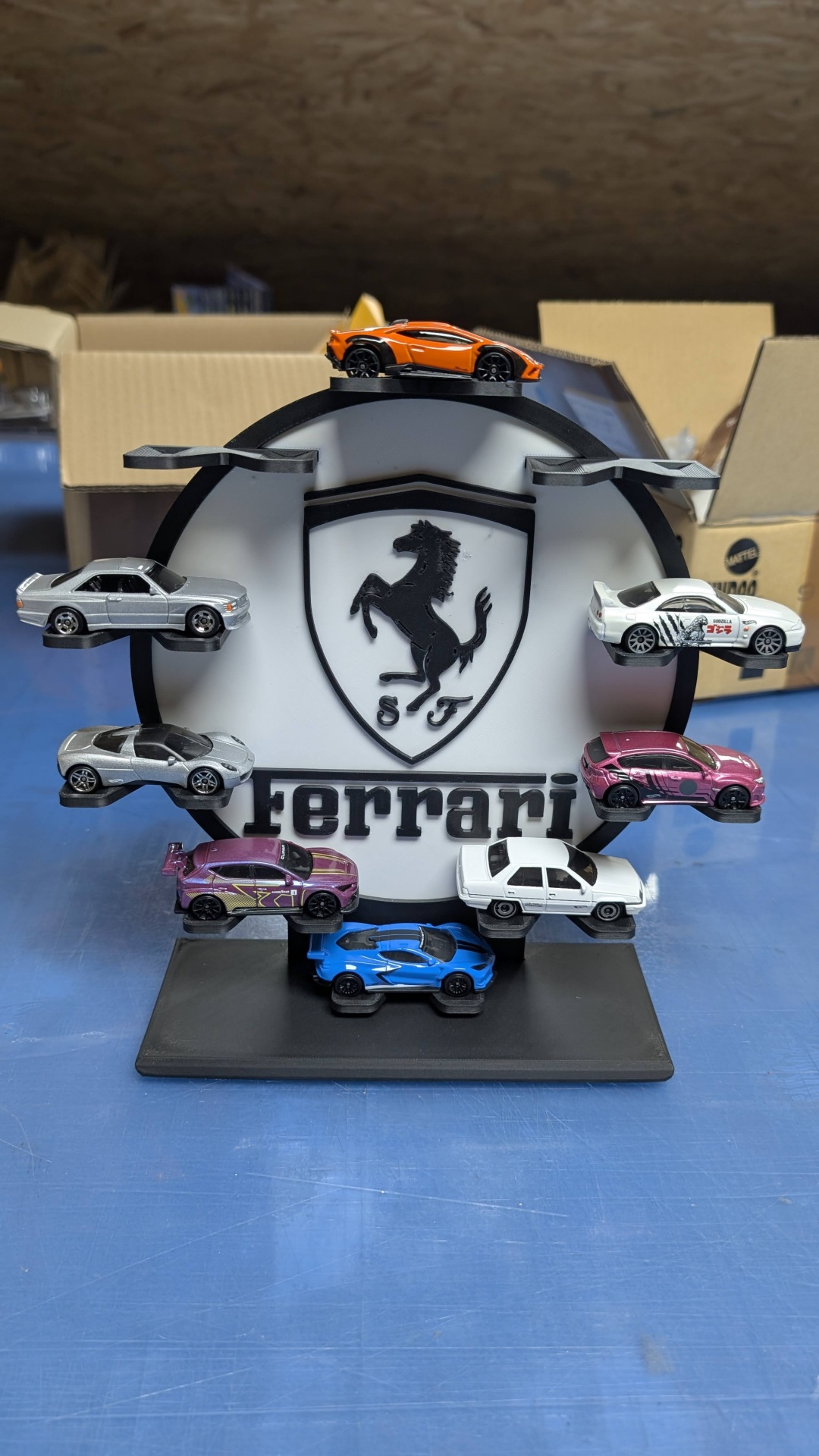 Suporte com miniaturas de carros e logótipo da Ferrari