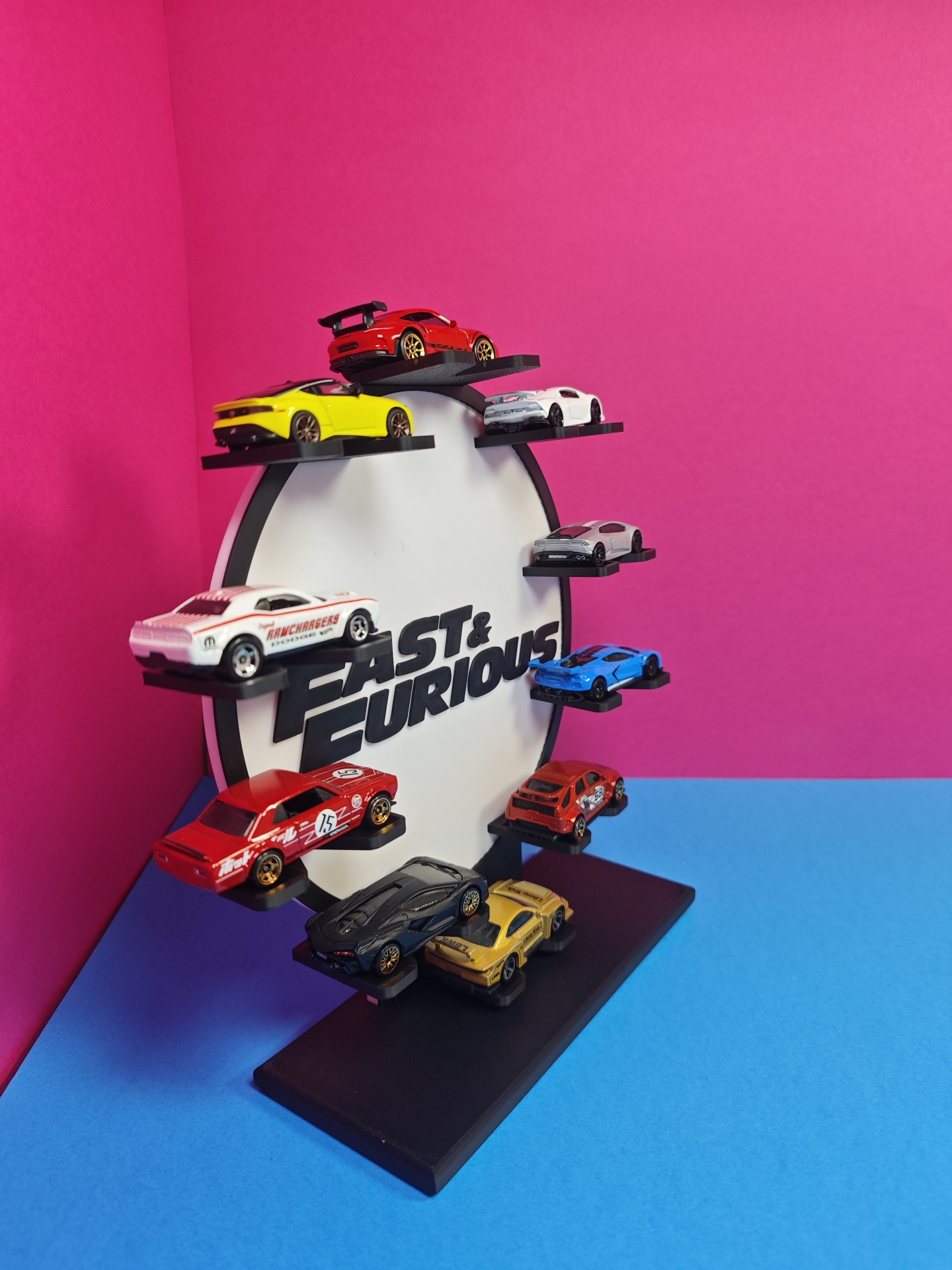 Expositor com carrinhos autónomos Fast & Furious em fundo colorido.