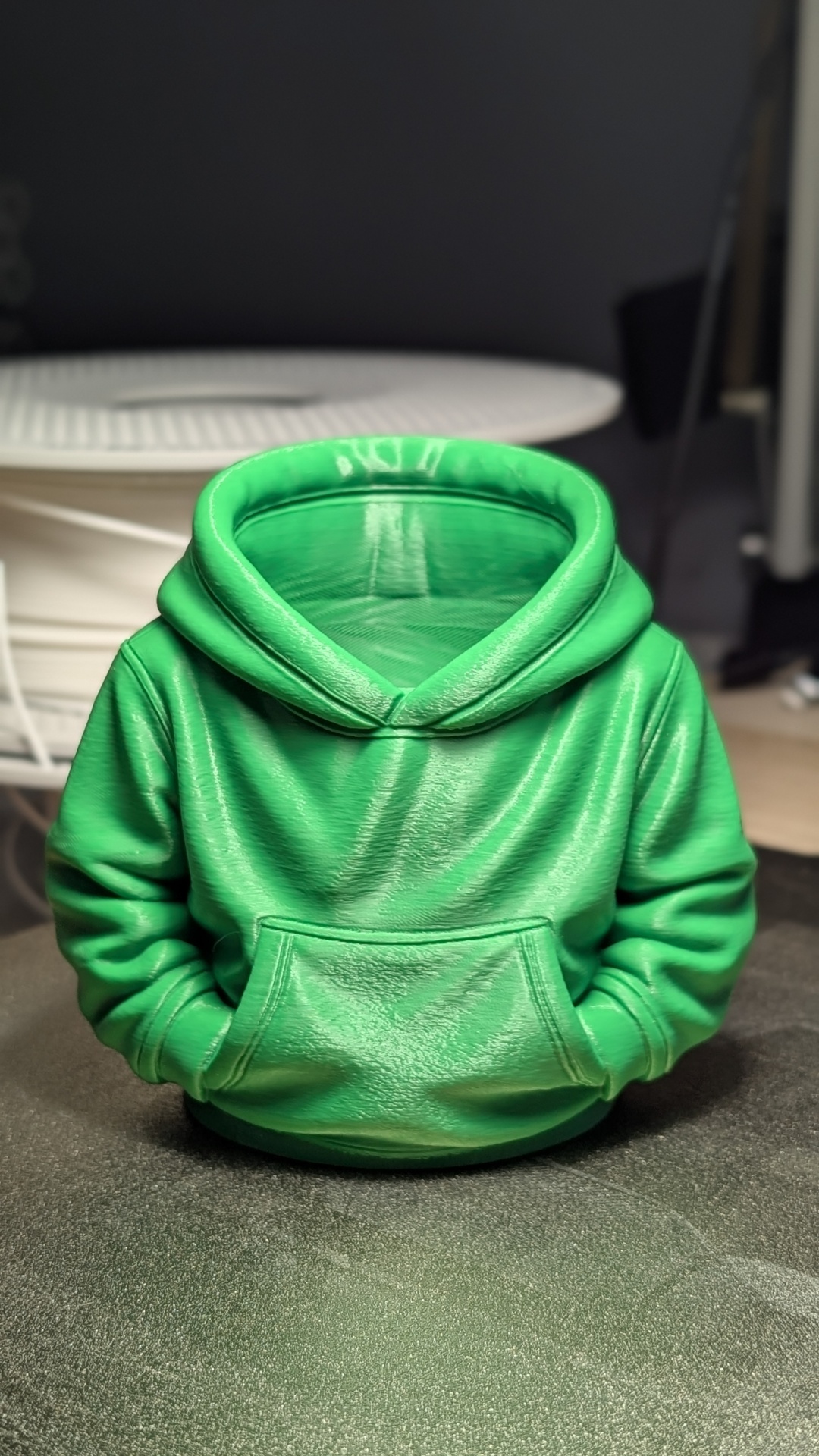 Suporte decorativo em forma de hoodie verde com capuz e bolso frontal.