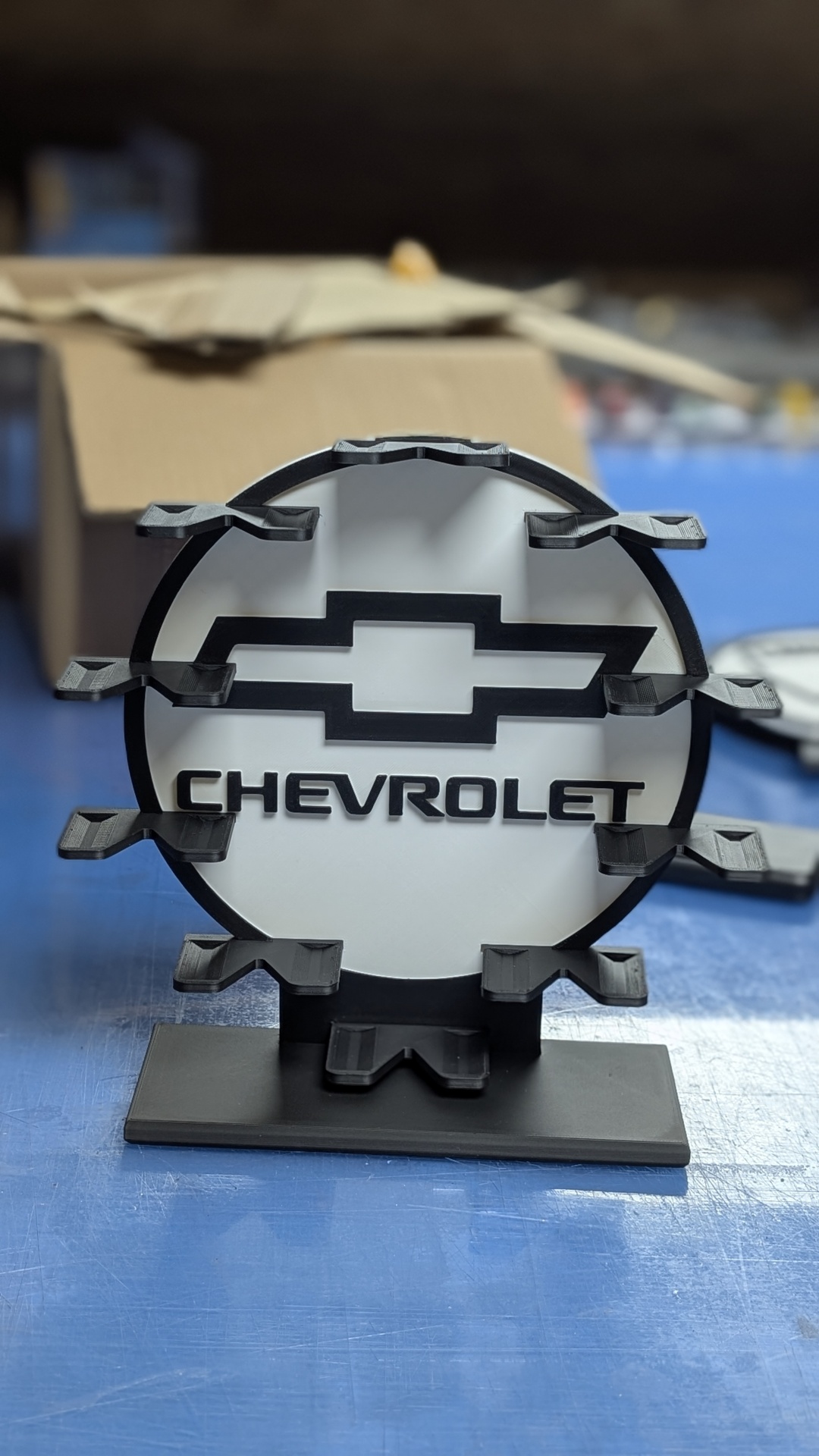 Suporte com logótipo CHEVROLET em preto e branco sobre superfície azul