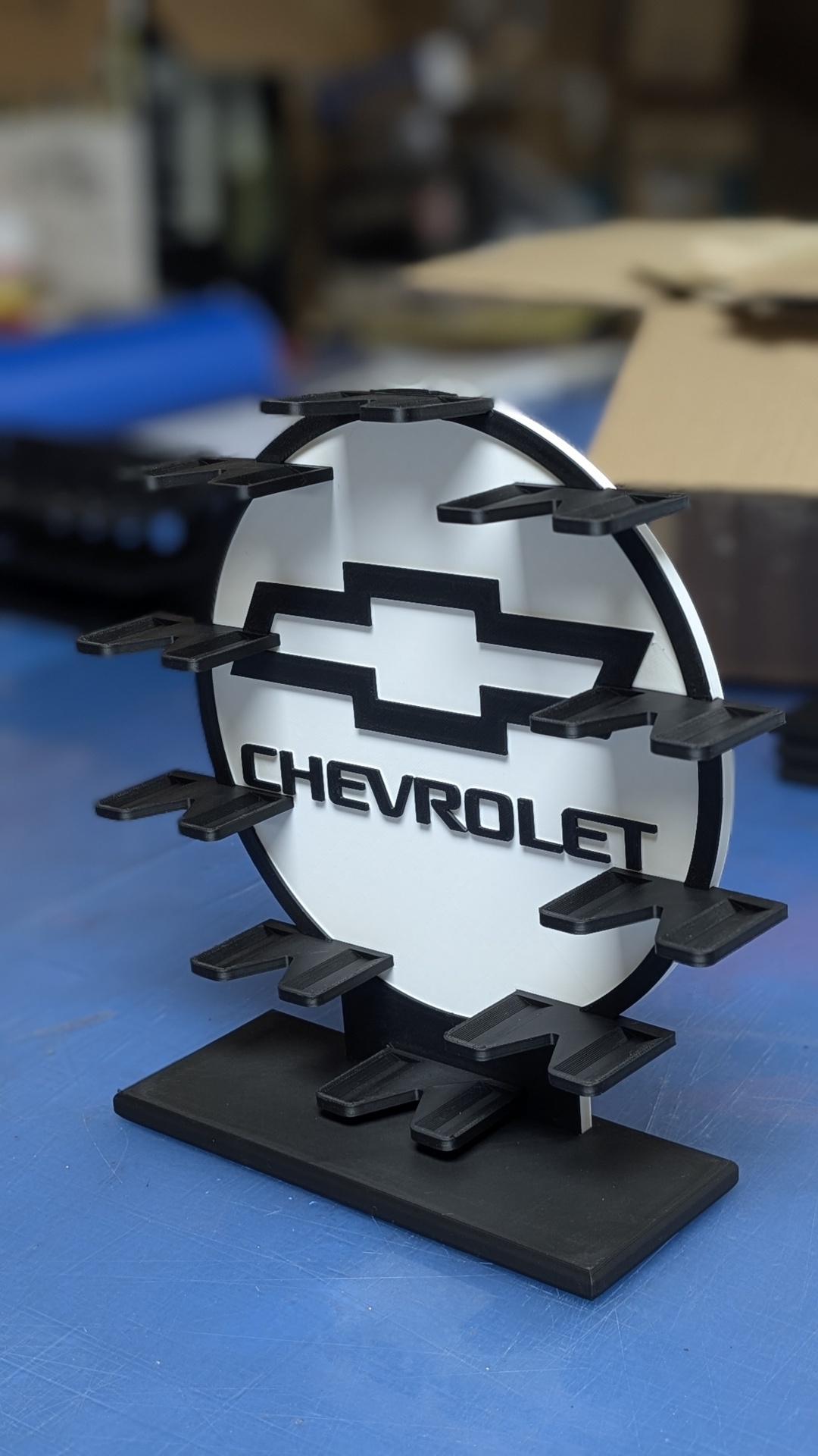 Expositor preto e branco com logotipo Chevrolet sobre superfície azul