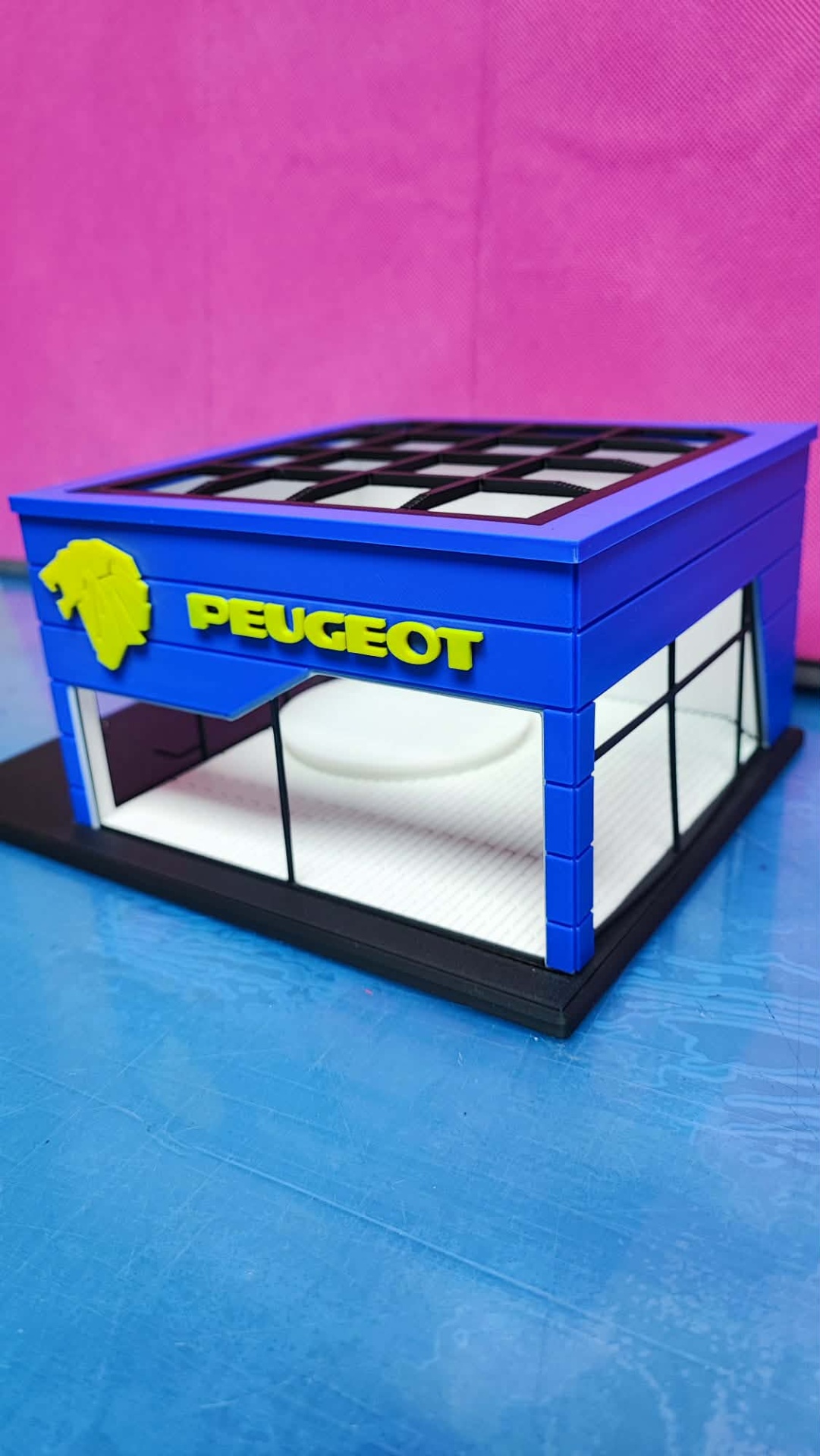 Miniatura de edifício com logotipo Peugeot em amarelo