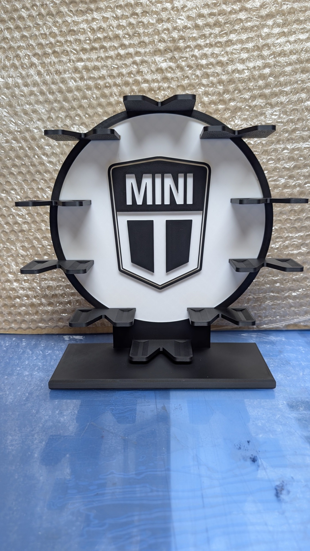 Suporte preto em plástico com base retangular e escudo MINI impresso
