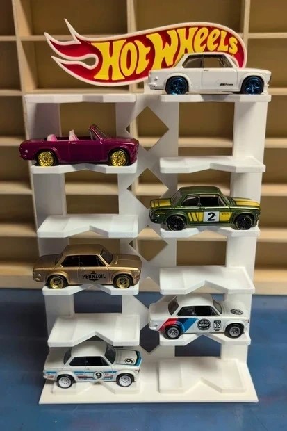 Suporte branco com seis carrinhos Hot Wheels coloridos e logo Hot Wheels ao fundo