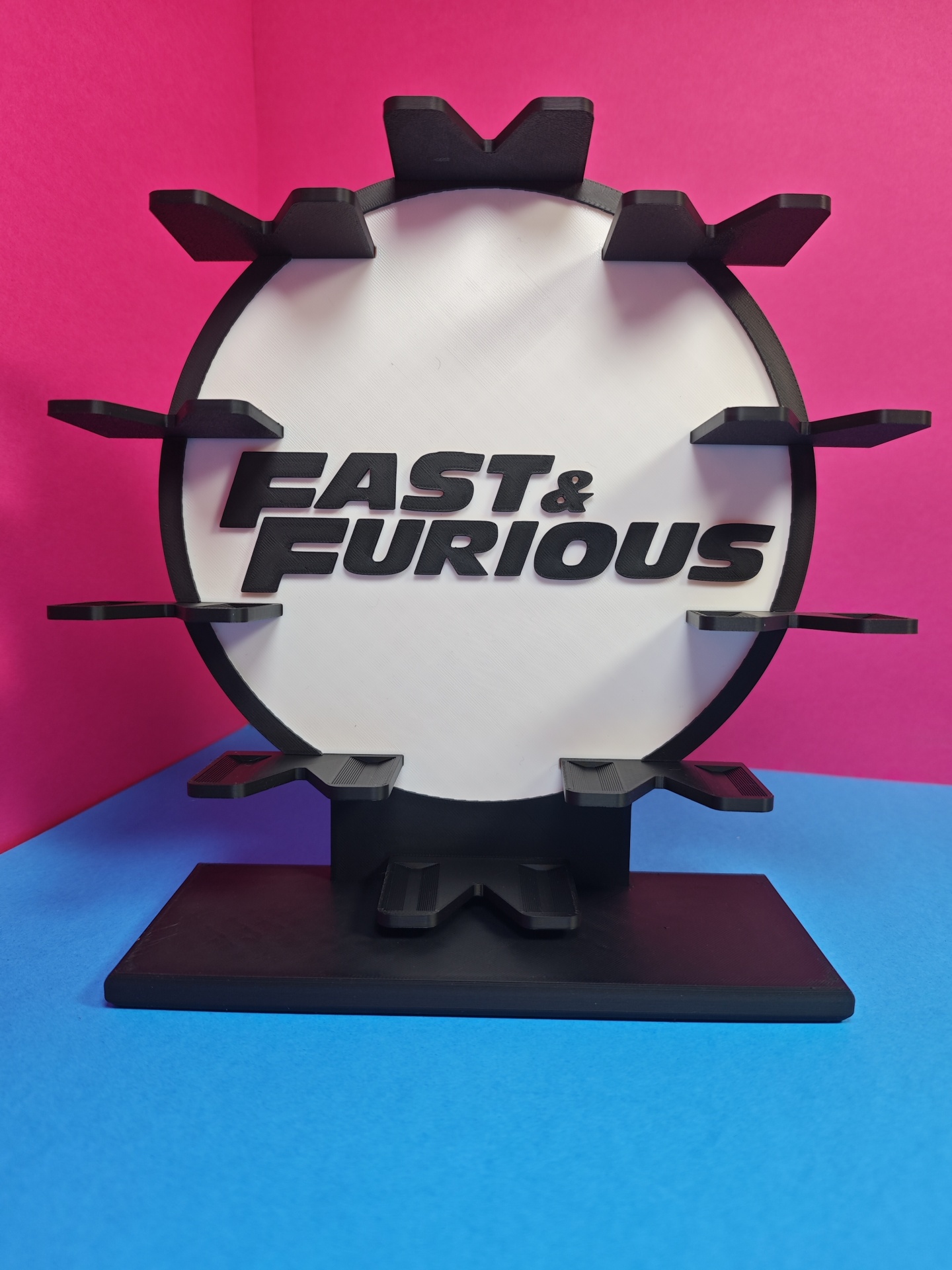 Suporte circular FAST & FURIOUS preto e branco sobre fundo rosa e azul