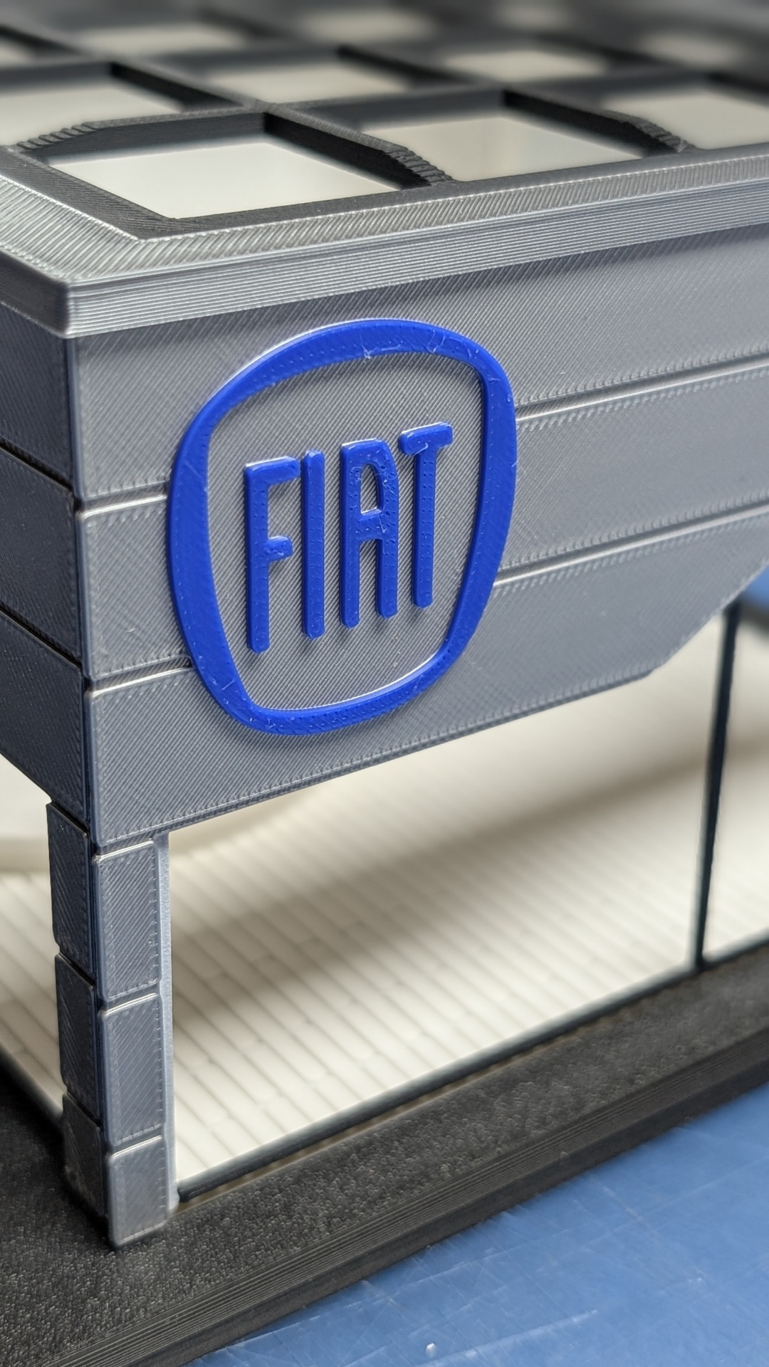 Miniatura cinzenta e preta com logotipo azul FIAT em relevo