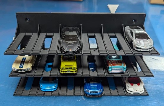 Carrinhos de brinquedo organizados em prateleiras pretas em superfície azul