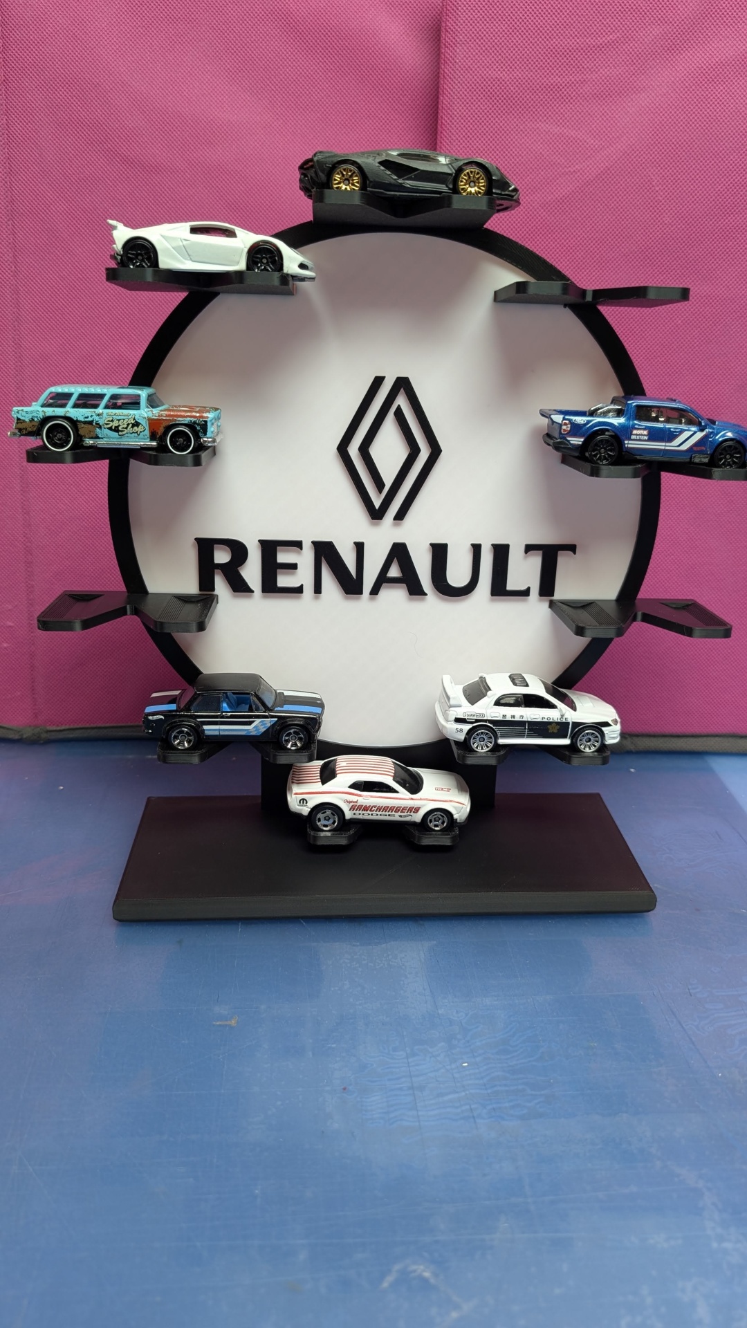Expositor circular preto com sete miniaturas de carros e logo Renault