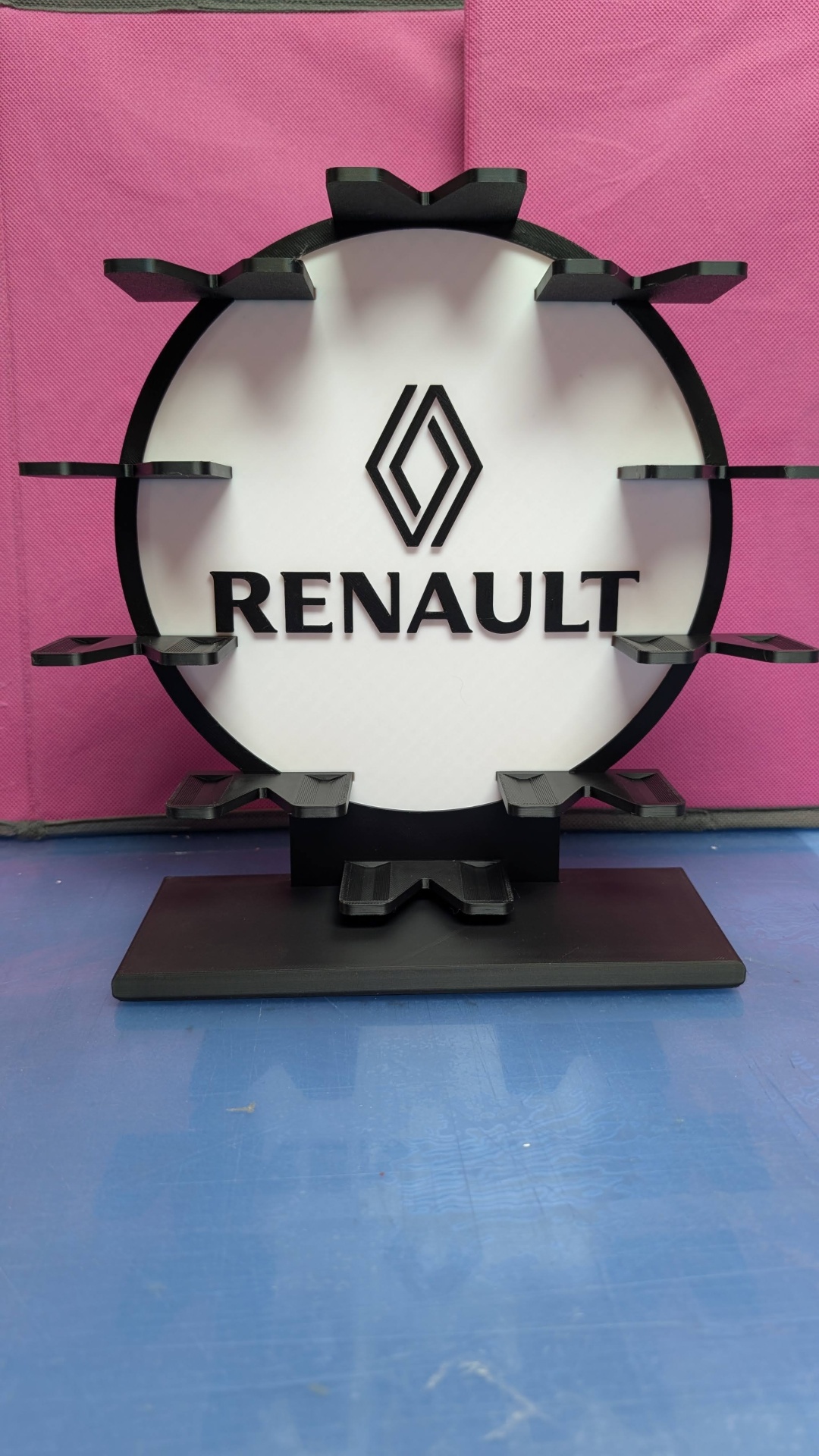 Suporte preto com logótipo e nome Renault num fundo branco e preto