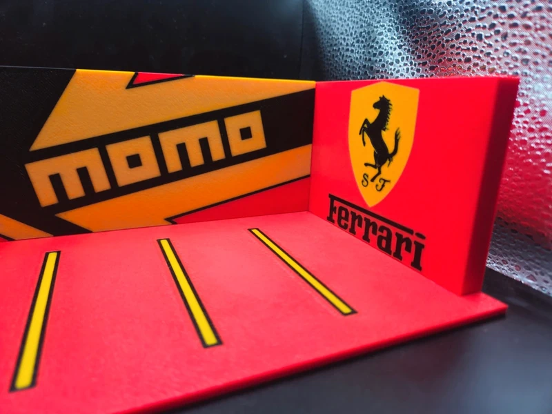 Miniatura de estacionamento com logos momo e ferrari em vermelho, amarelo e preto