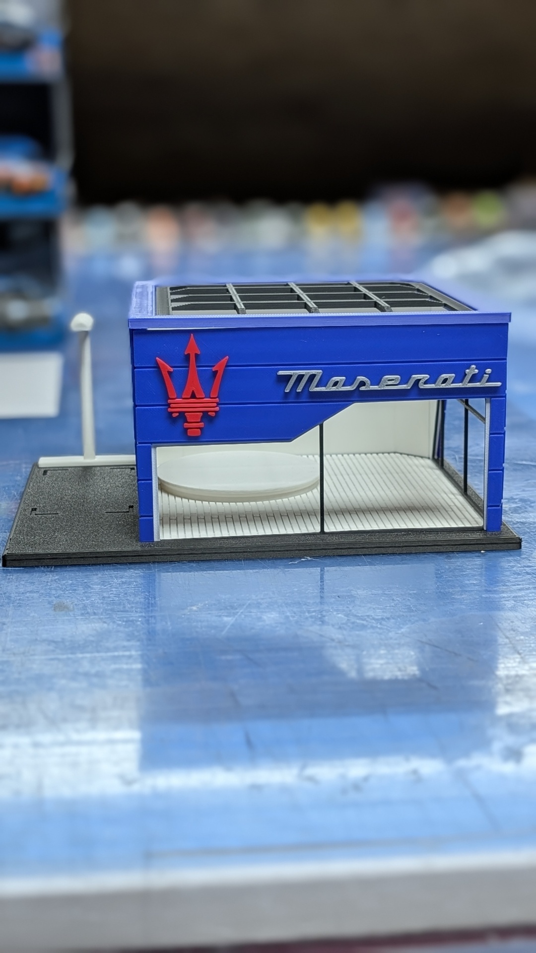 Miniatura de loja Maserati azul com logotipo vermelho