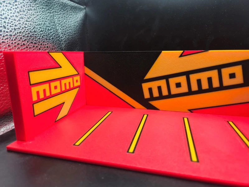 Peça vermelha e preta com design e texto momo em amarelo e vermelho