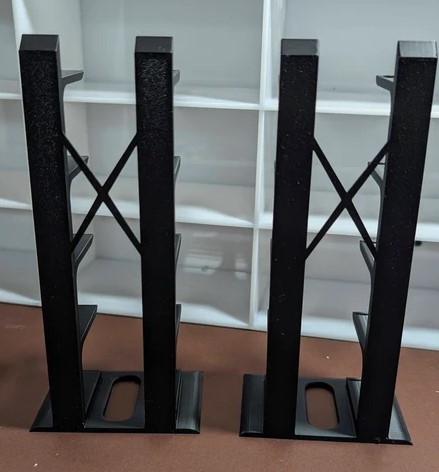 Dois suportes metálicos pretos verticais com barras cruzadas