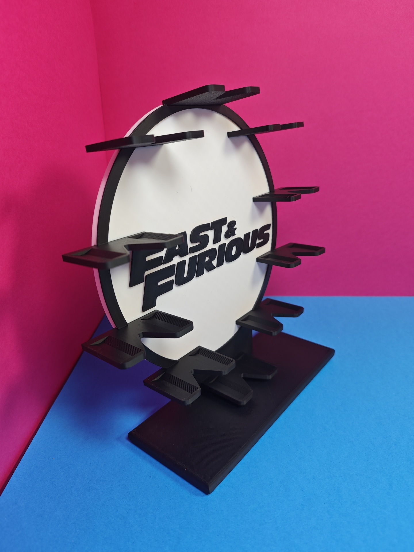 Suporte de plástico preto e branco com texto FAST & FURIOUS e vários suportes salientes