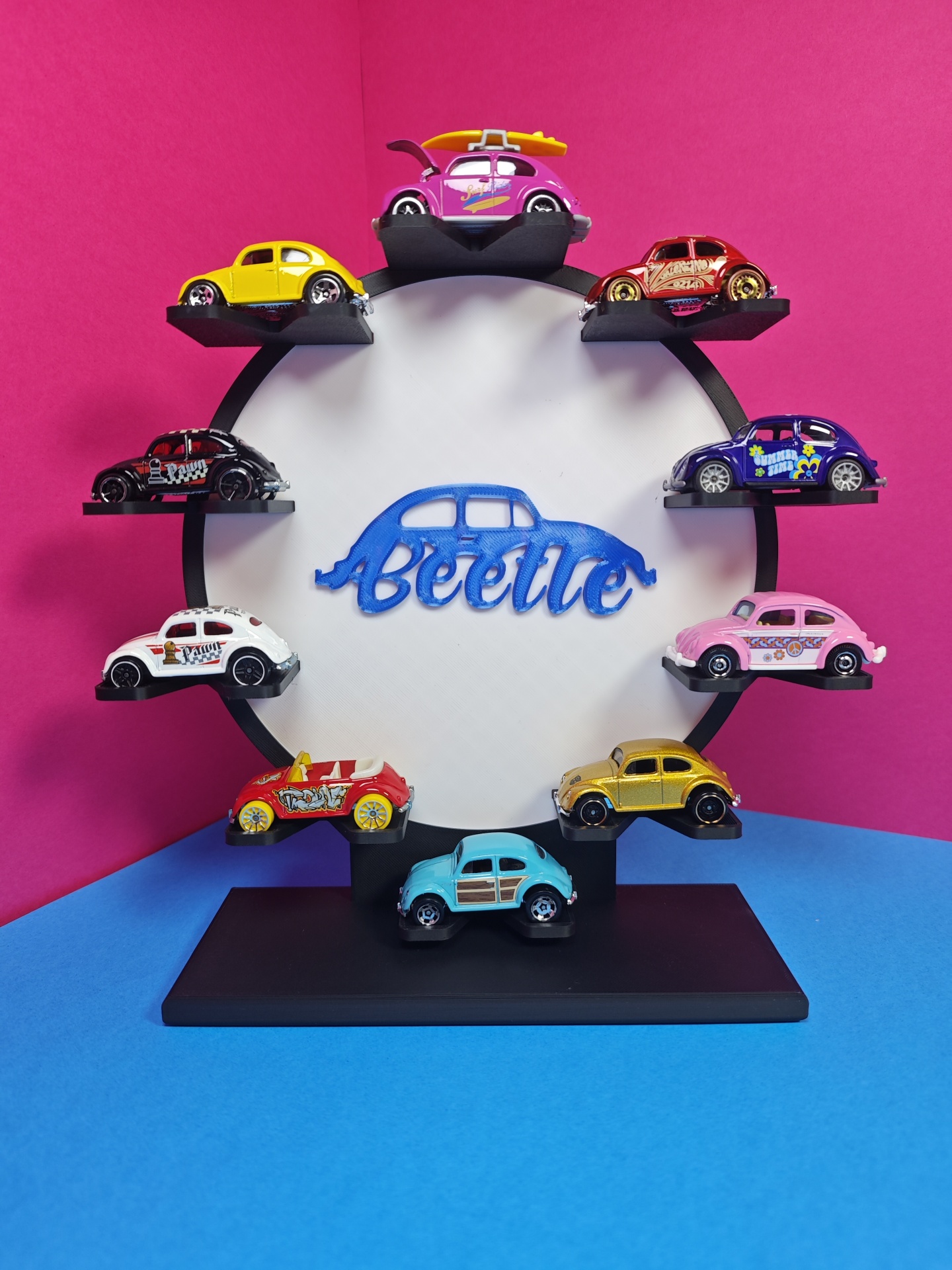 Miniaturas coloridas de carros Beetle em suporte com a palavra Beetle no centro