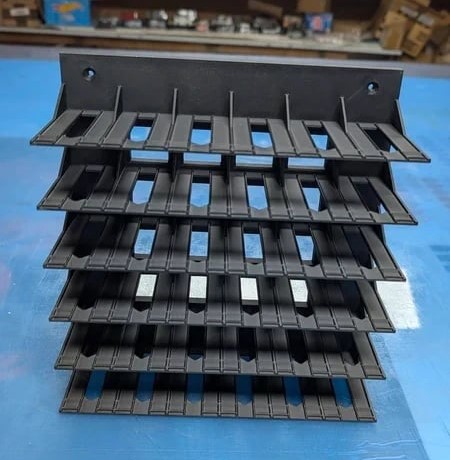 Estrutura preta de plástico com 5 níveis de ranhuras retangulares