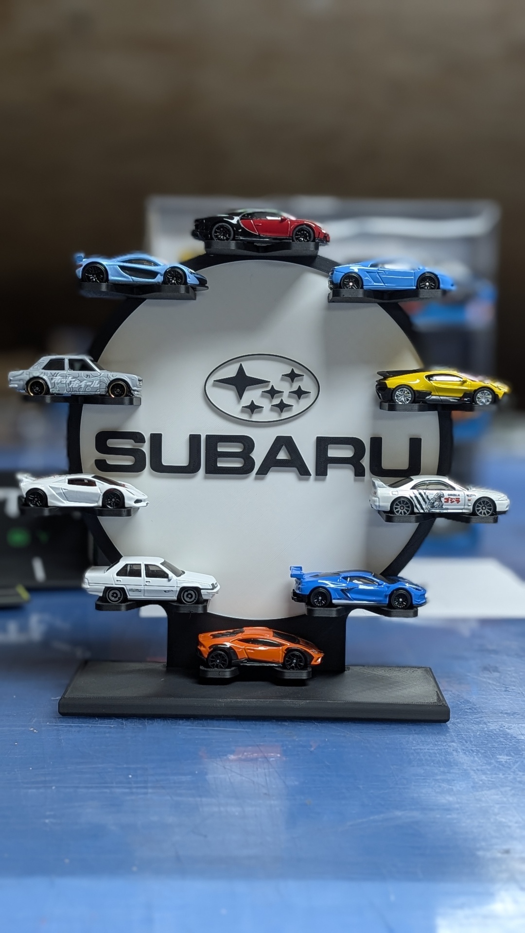 Expositor circular SUBARU com carros de brinquedo em miniatura