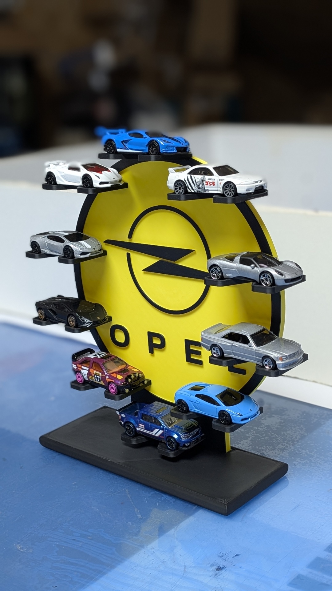 Expositor amarelo Opel com miniaturas de carros coloridos