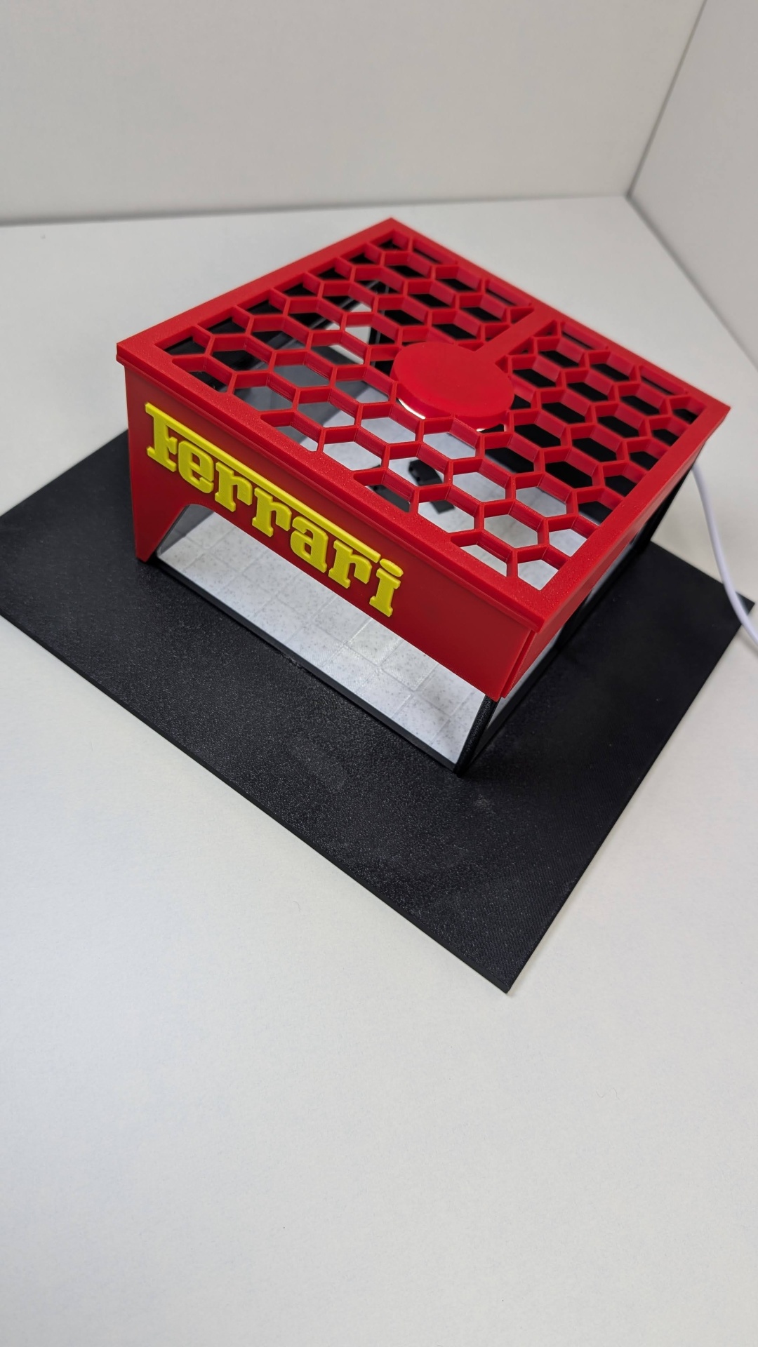 Miniatura de stand Ferrari vermelho com letras amarelas e base preta
