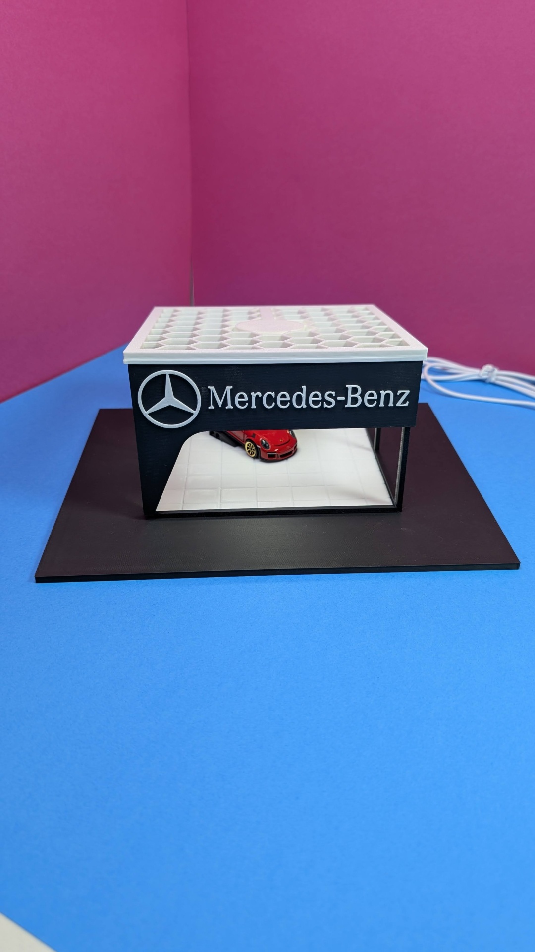 Miniatura de loja Mercedes-Benz com carro vermelho no interior