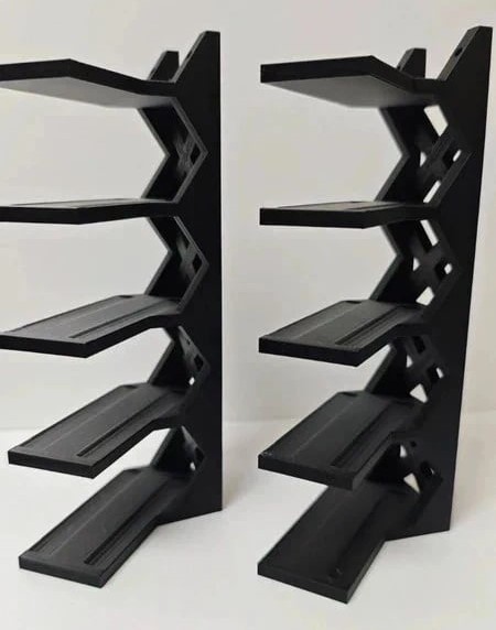 Suportes pretos de prateleira em material plástico com recortes geométricos