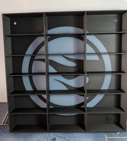 Estante preta modular com 20 compartimentos e padrão circular azul e preto ao fundo