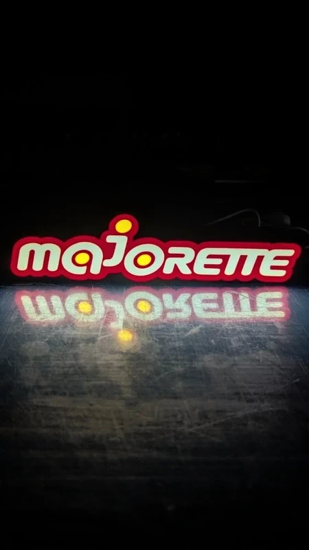 Letreiro luminoso Majorette com letras brancas e contorno vermelho