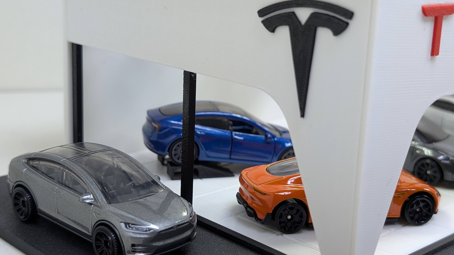 Miniaturas de carros Tesla em exposição com logotipo da Tesla