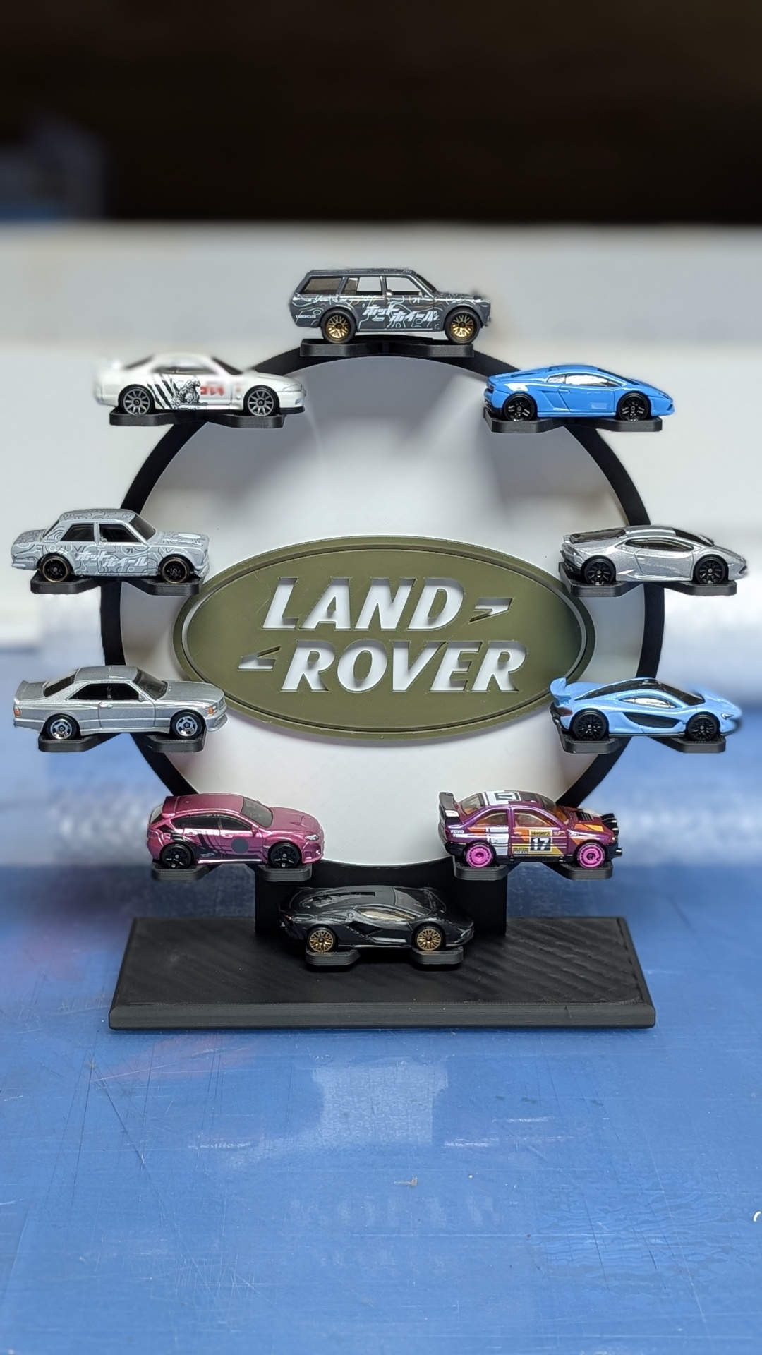 Expositor preto com miniaturas de carros e logótipo Land Rover