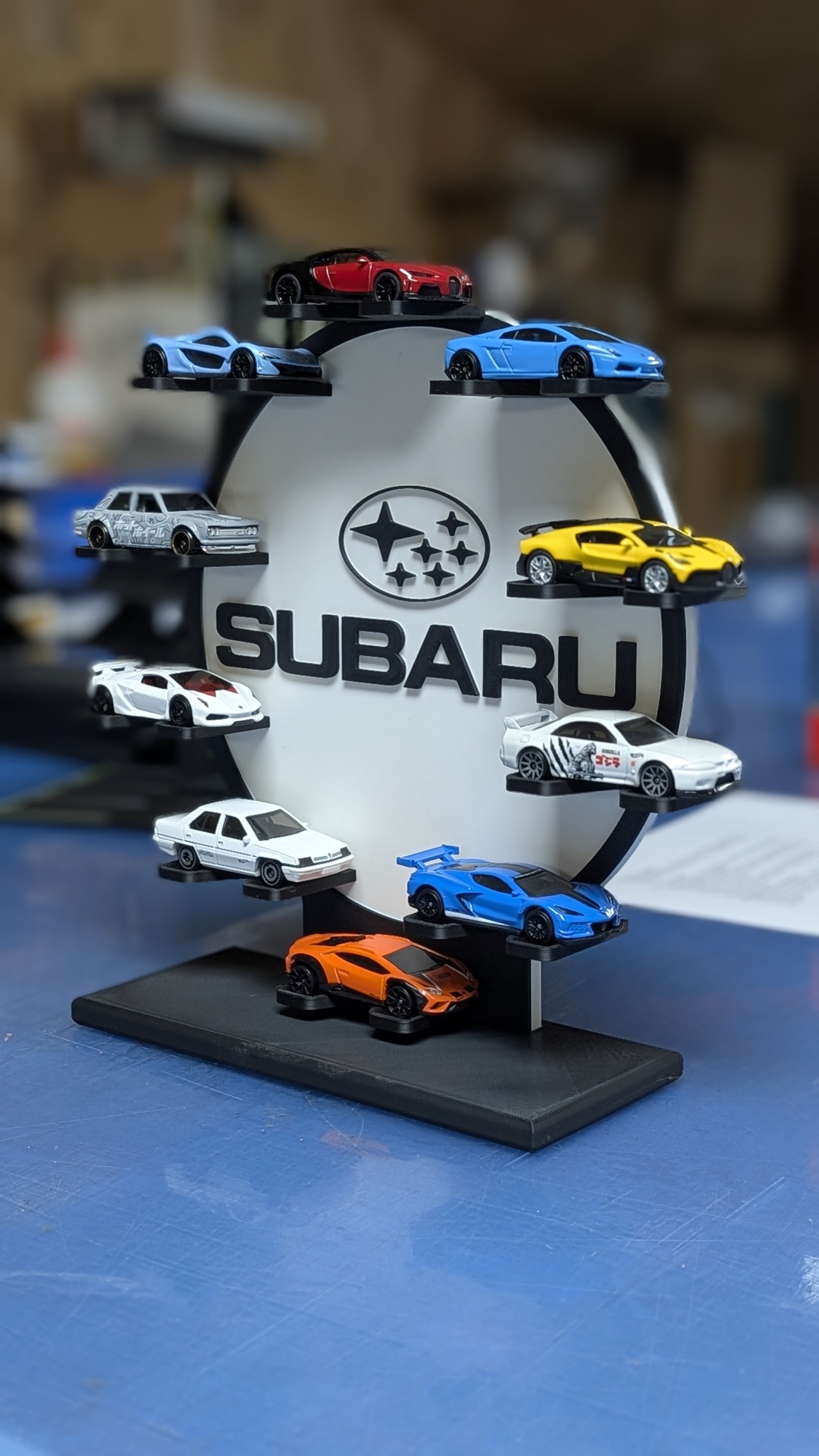 Miniaturas de carros coloridos num suporte com logótipo SUBARU