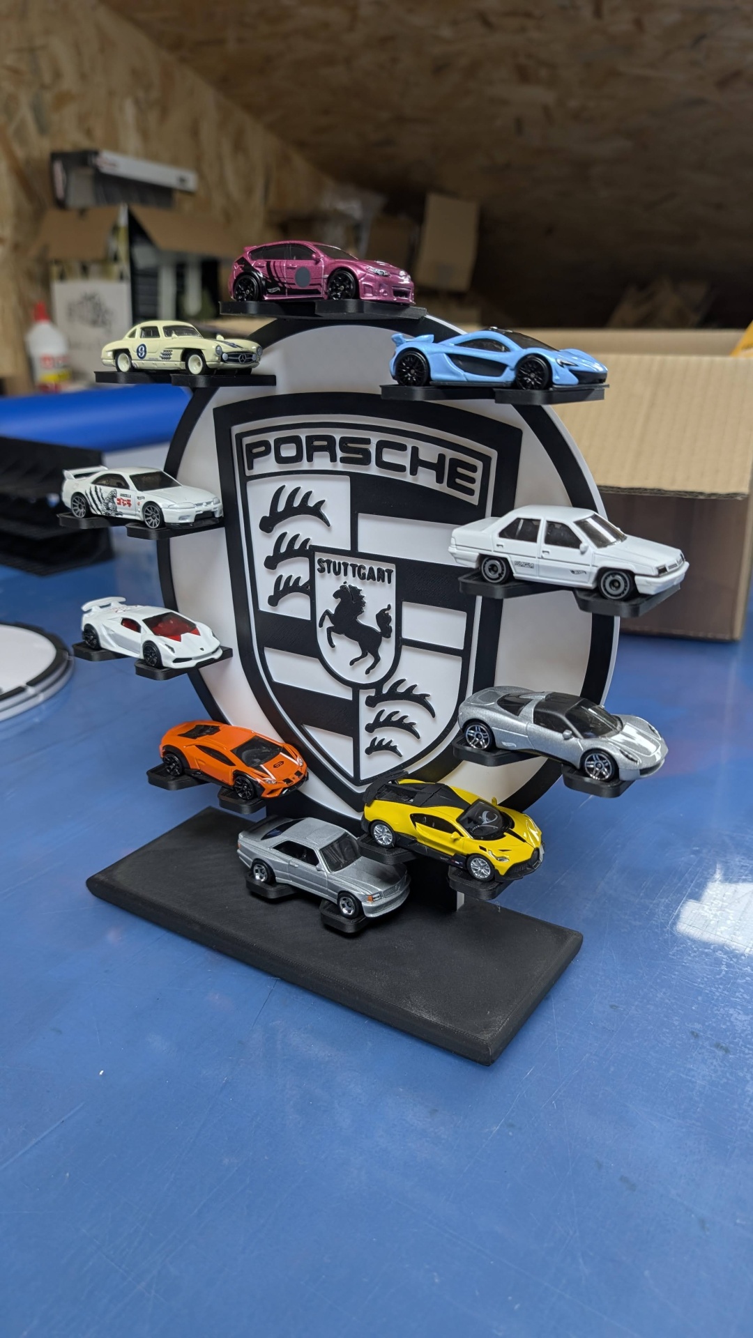 Expositor com miniaturas de carros Porsche de várias cores e modelos