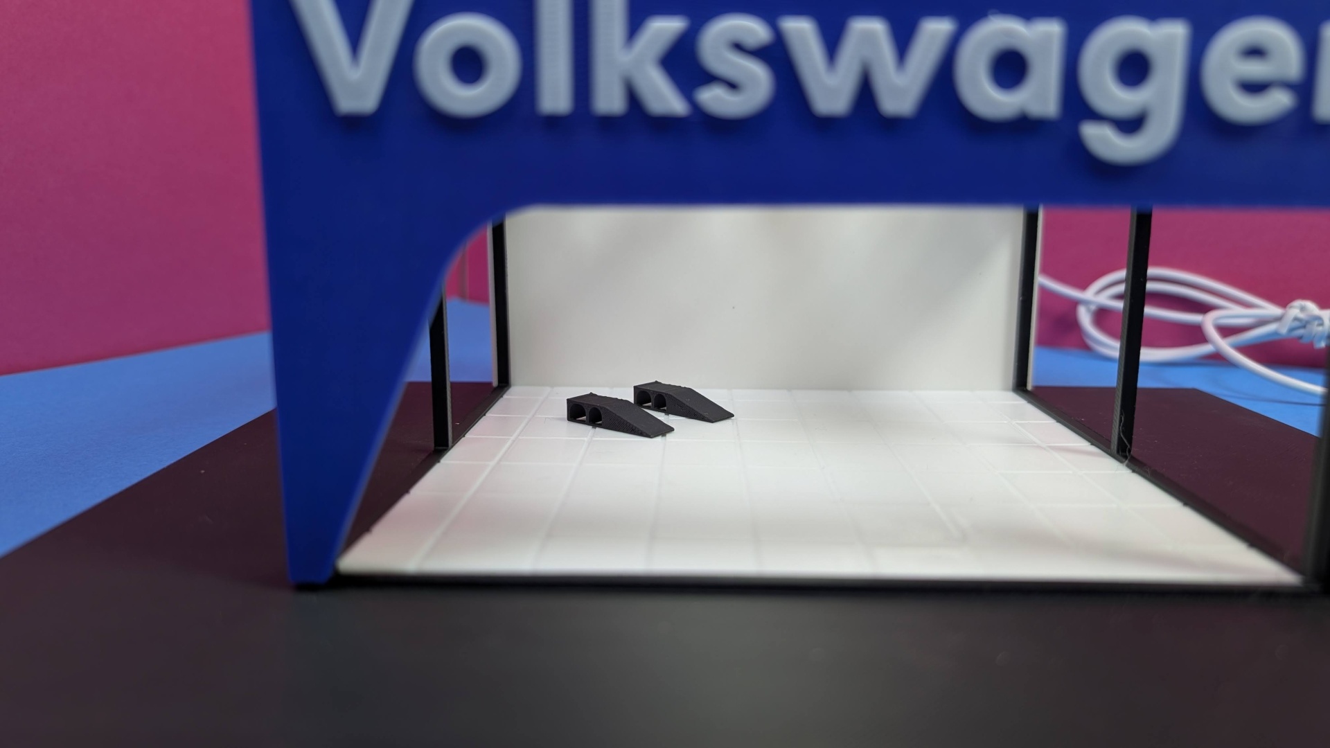 Miniatura de garagem com texto Volkswagen e duas calhas pretas no interior