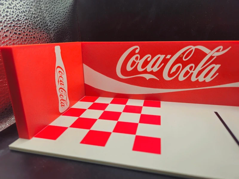 Estrutura com padrão xadrez e logo Coca-Cola em vermelho e branco