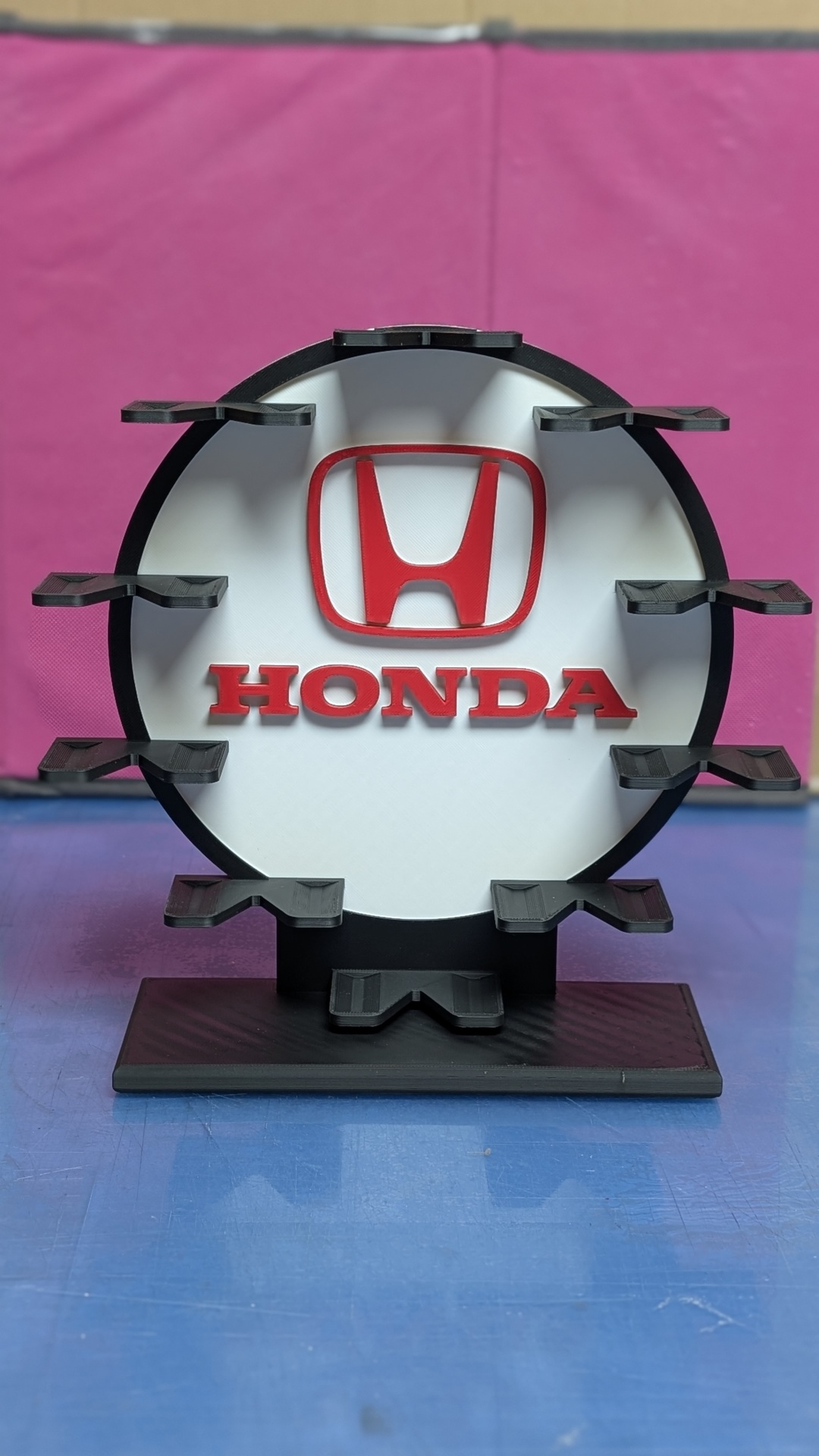 Suporte de exposição redondo com logos Honda e apoios pretos