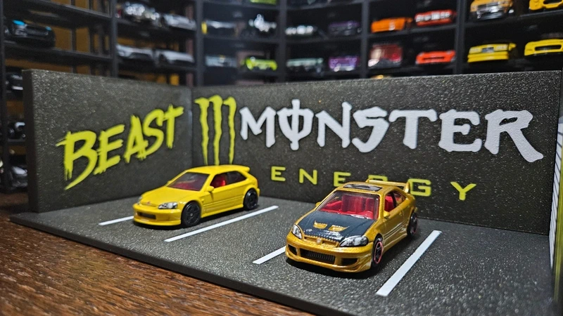 Miniaturas de carros amarelos em exposição com fundo Beast Monster Energy