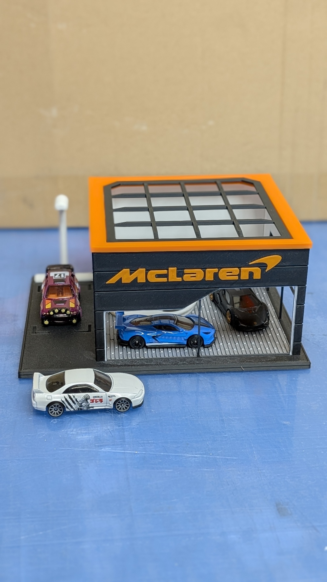 Miniatura de garagem McLaren com carros de brinquedo em plástico