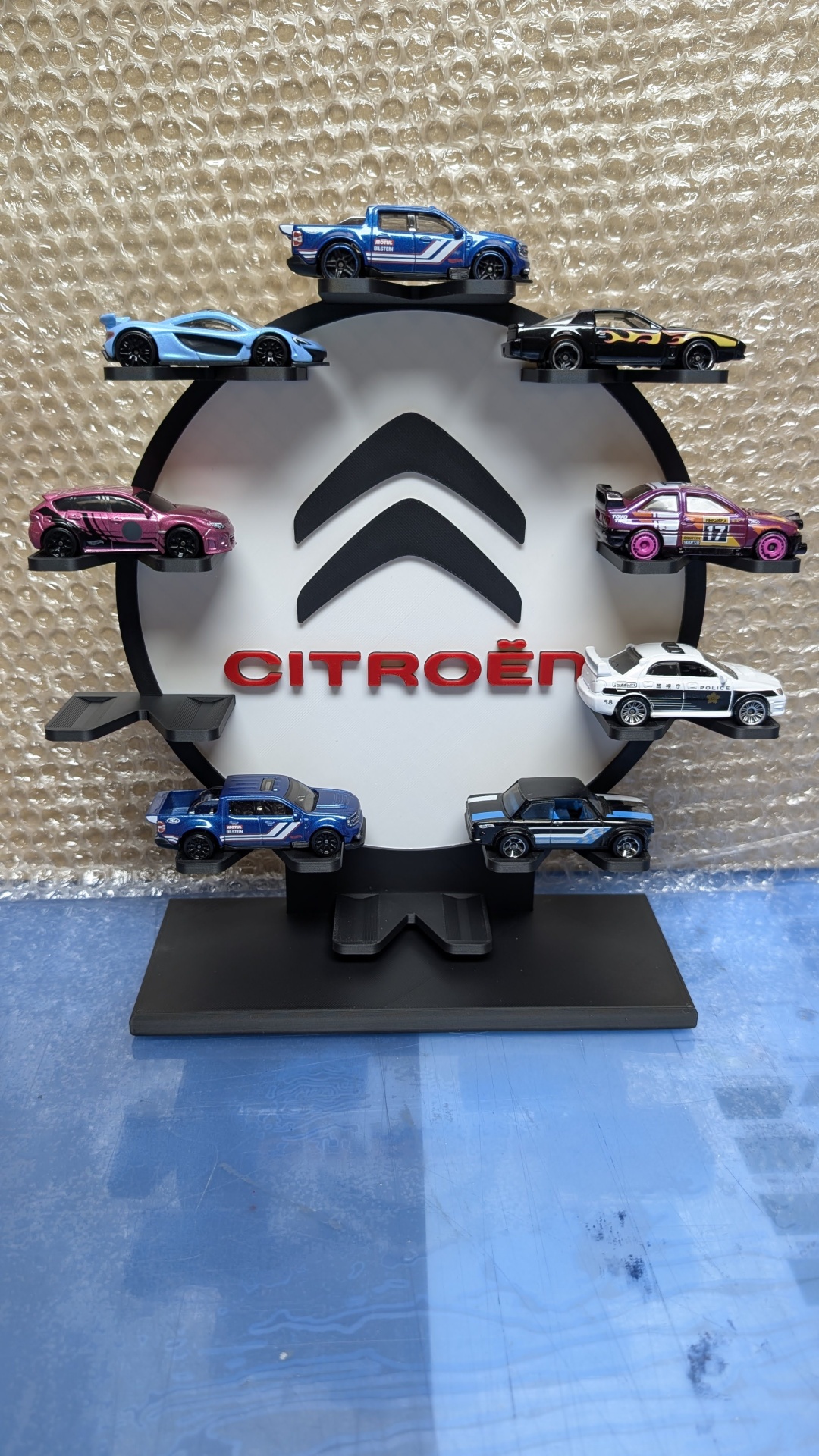 Expositor com logotipo Citroën e miniaturas variadas de carros