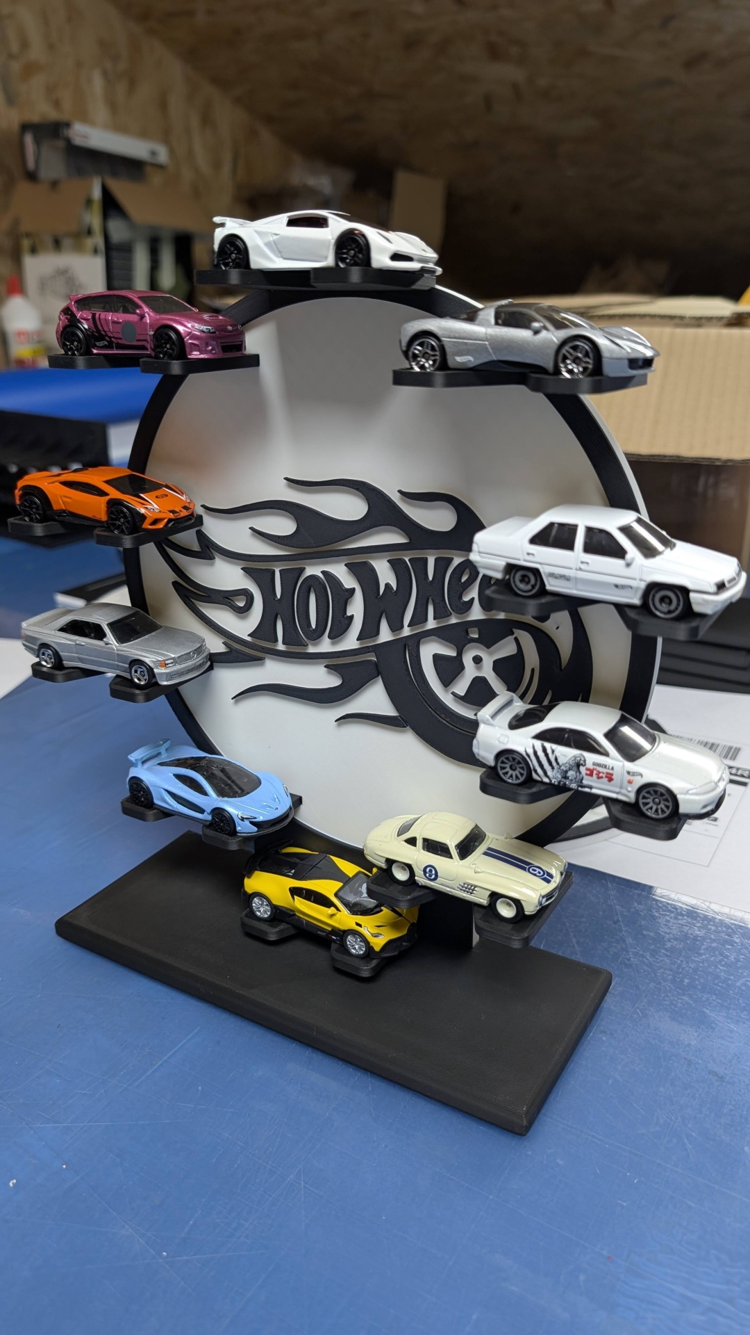 Expositor circular Hot Wheels com 10 carros de brinquedo em miniatura de várias cores e detalhes.