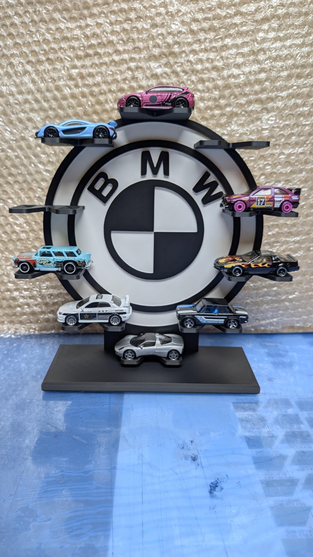 Carrinhos miniatura coloridos em suporte com logotipo BMW