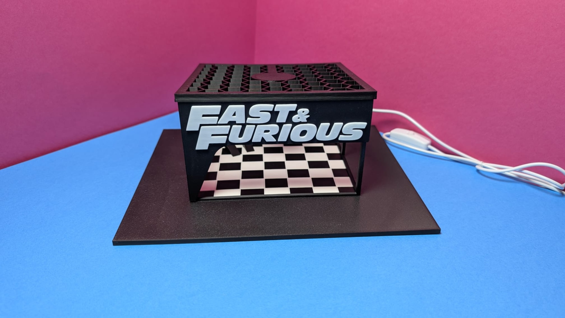 Suporte preto com texto FAST & FURIOUS e base xadrez preto e branco