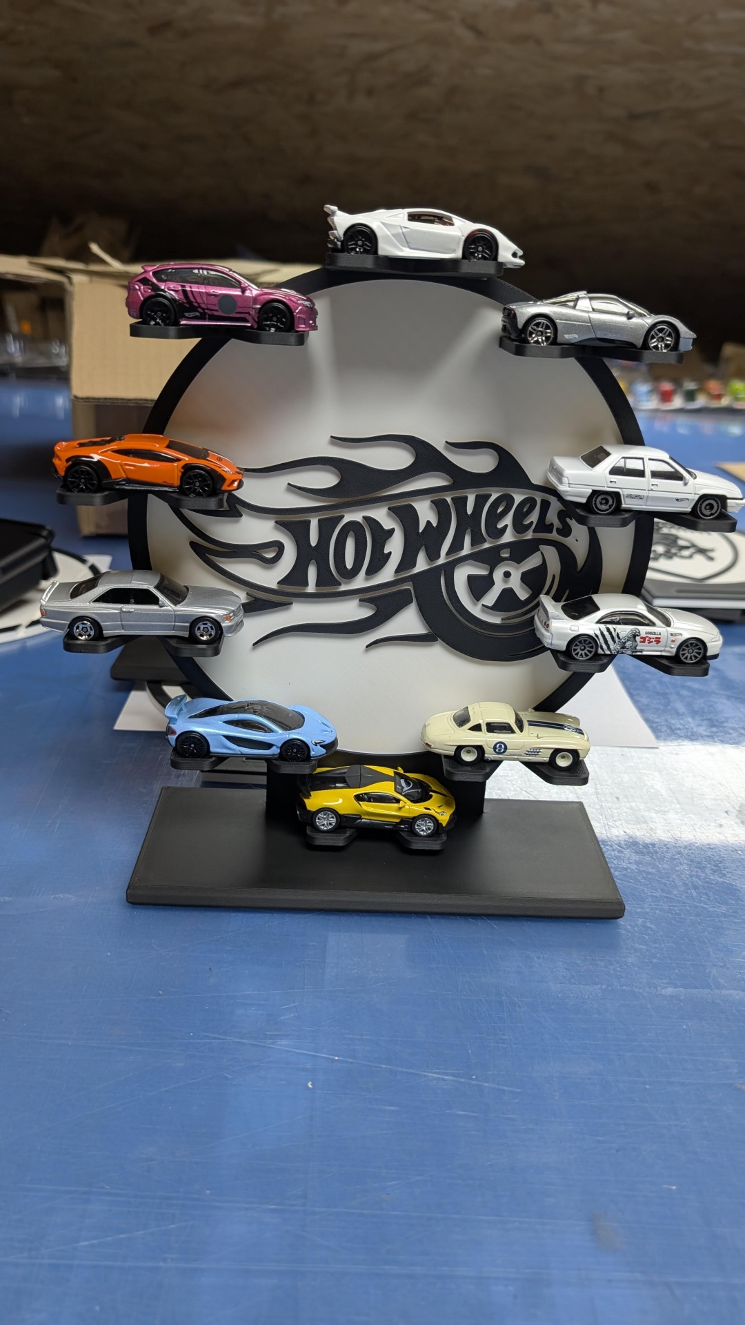 Conjunto de 10 carrinhos Hot Wheels em base de exposição preta com logo Hot Wheels