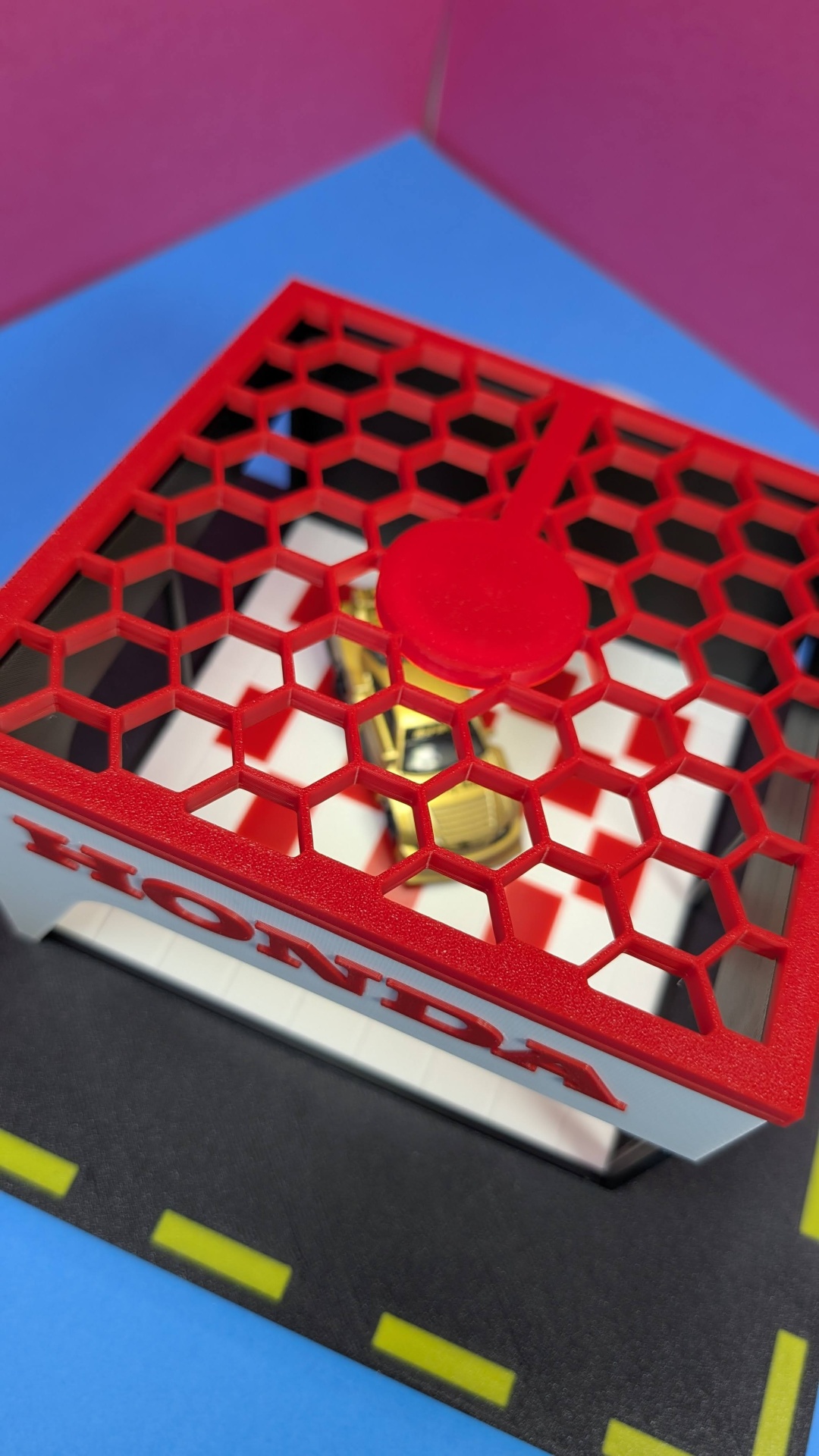 Modelo miniatura de estacionamento com cobertura vermelha e texto HONDA