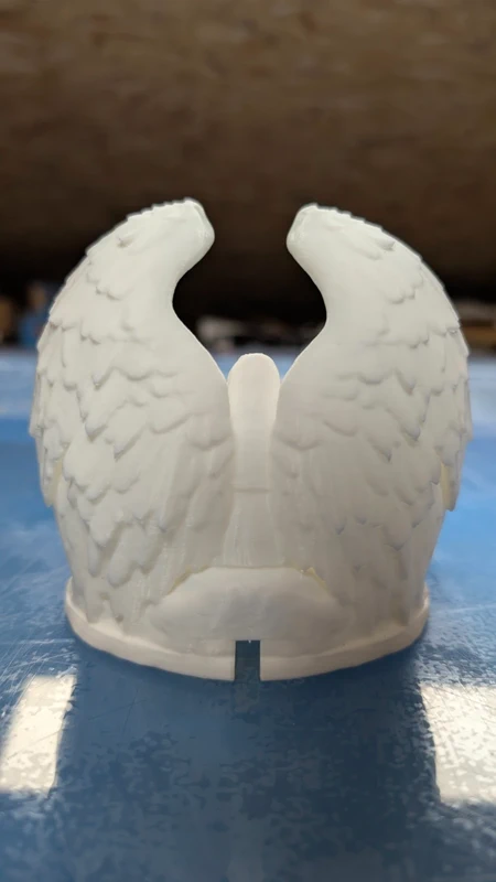 Coroa branca com asas de anjo detalhadas em material rígido